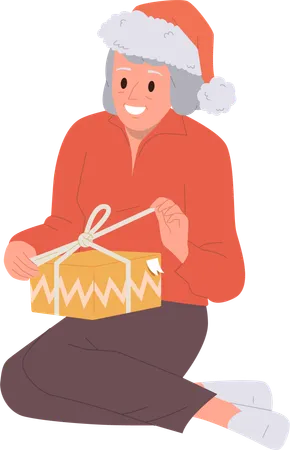 Elderly Aged Woman Cartoon Character In Festive Christmas Hat Feeling Happy Opening Wrapped Gift Box Tied With Ribbon Having Surprise Unboxing Package With Unexpected Bonus Prize Vector Illustration Illustration