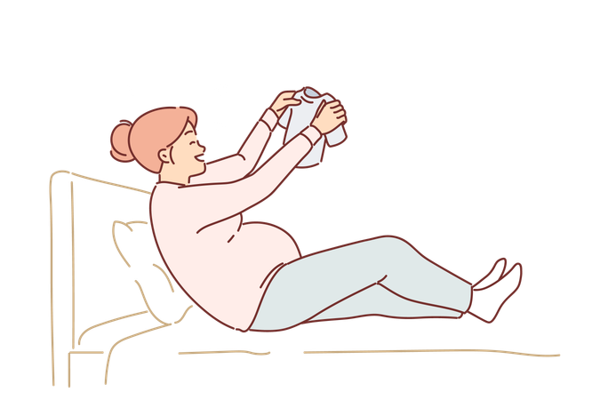 Une femme enceinte heureuse est assise sur le lit, tenant un petit t-shirt pour bébé et sourit  Illustration