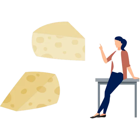 Fille assise sur une table et pointant du fromage  Illustration