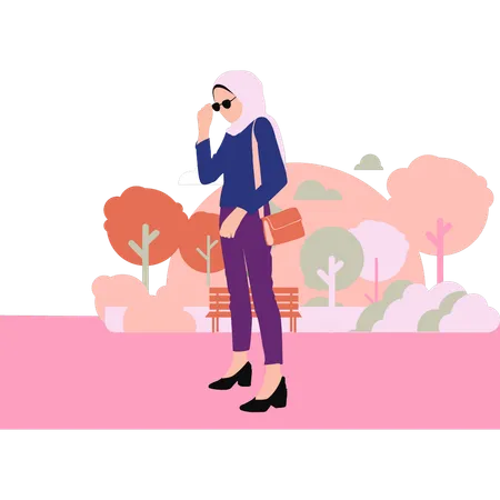 Hijabi girl is standing in the park  イラスト