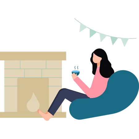 La niña está bebiendo té junto a la chimenea.  Ilustración